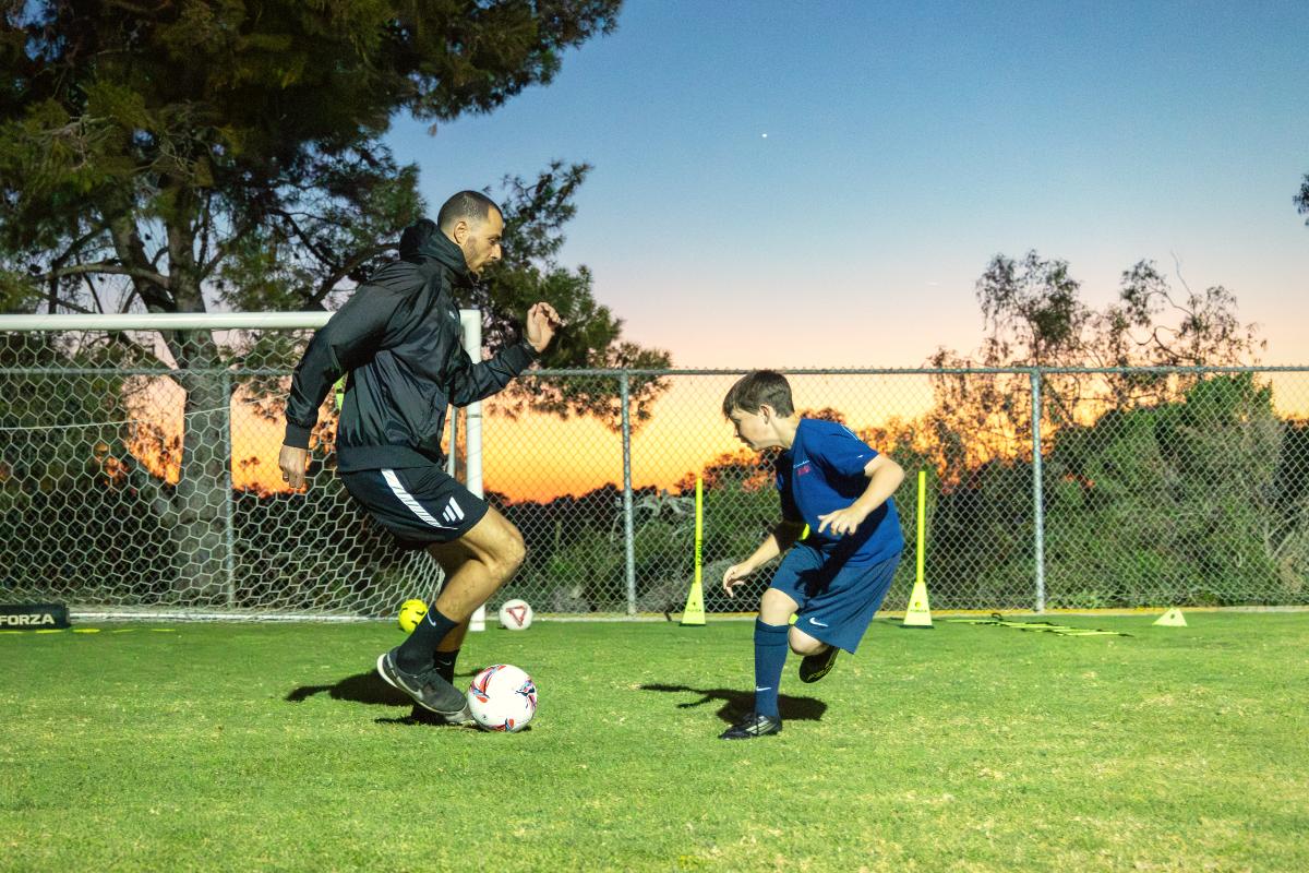 A player and Coach Luka face off 1v1 at sunset, tryout preparation at The Soccer Lab, Carlsbad